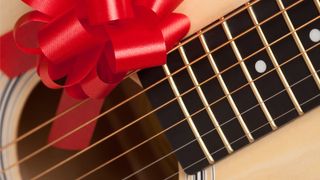Acoustic guitar wrapped with a red bow