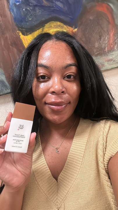 A girl in a tan shirt after applying spf.