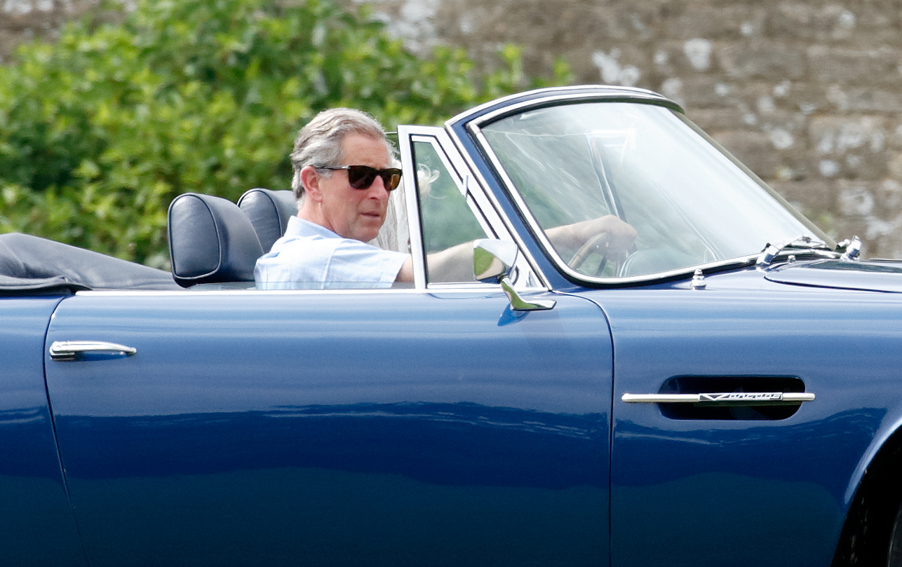 King Charles driving his convertible Aston Martin