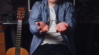 Man handcuffed next to an acoustic guitar