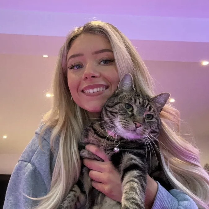 Megan Milstead holding her cat Nala while smiling