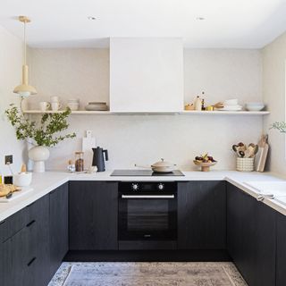 A kitchen with black vinyl-wrapped cupboards and open shelves