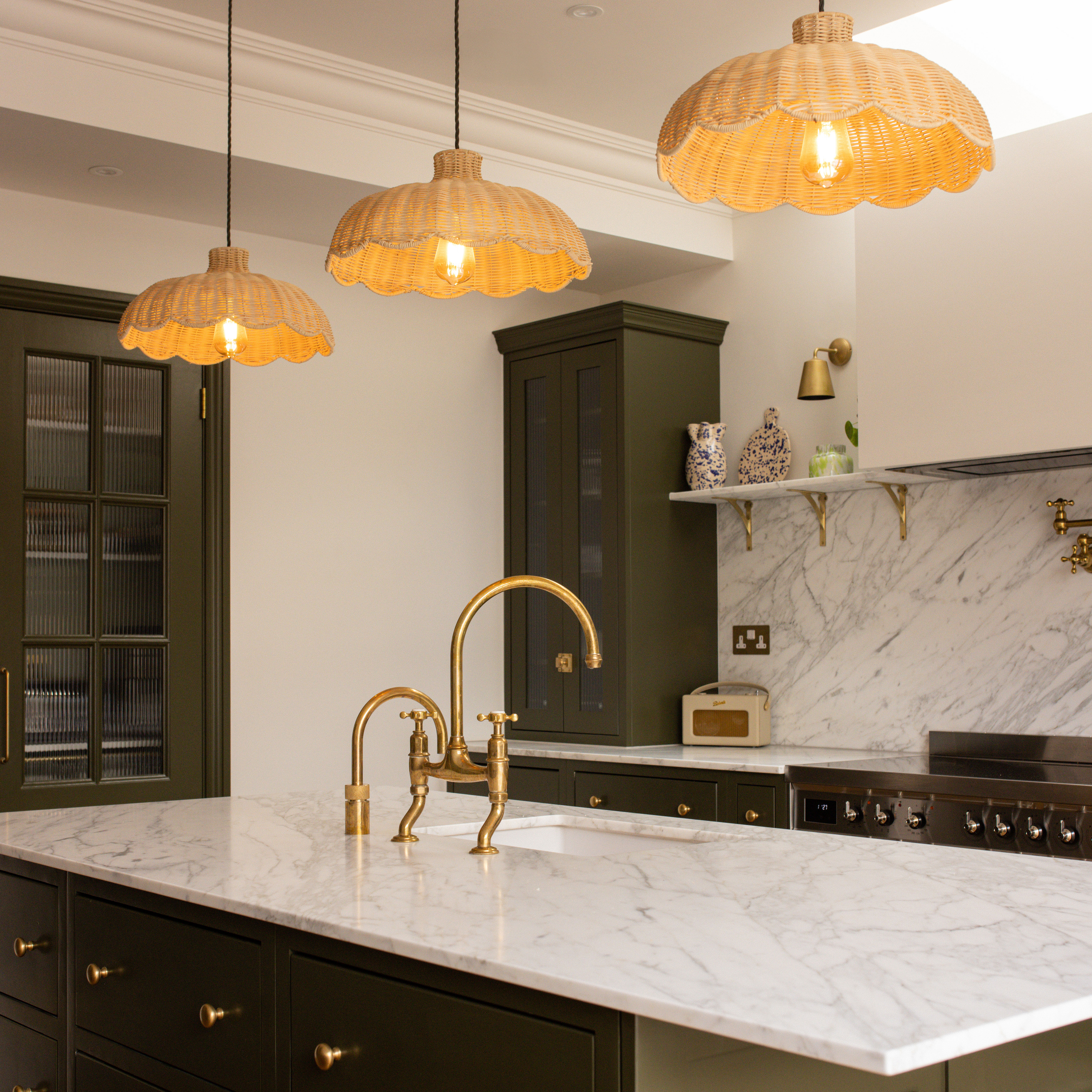 Three scalloped rattan pendant lampshades above kitchen island