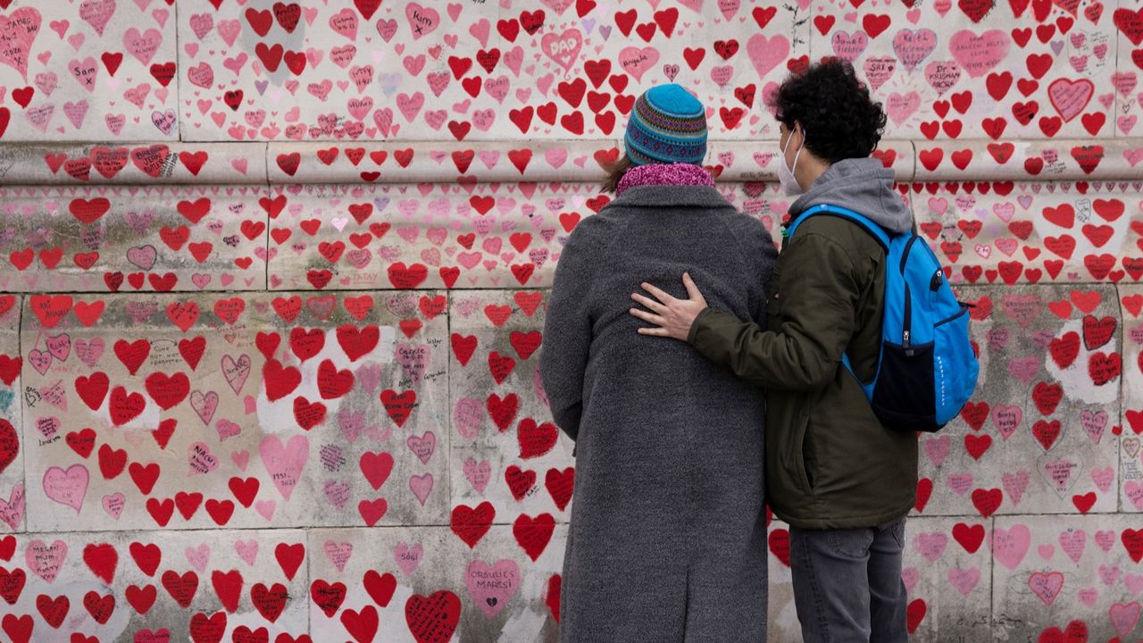 Members of the public look at a wall of remembrance for Covid-19 victims 