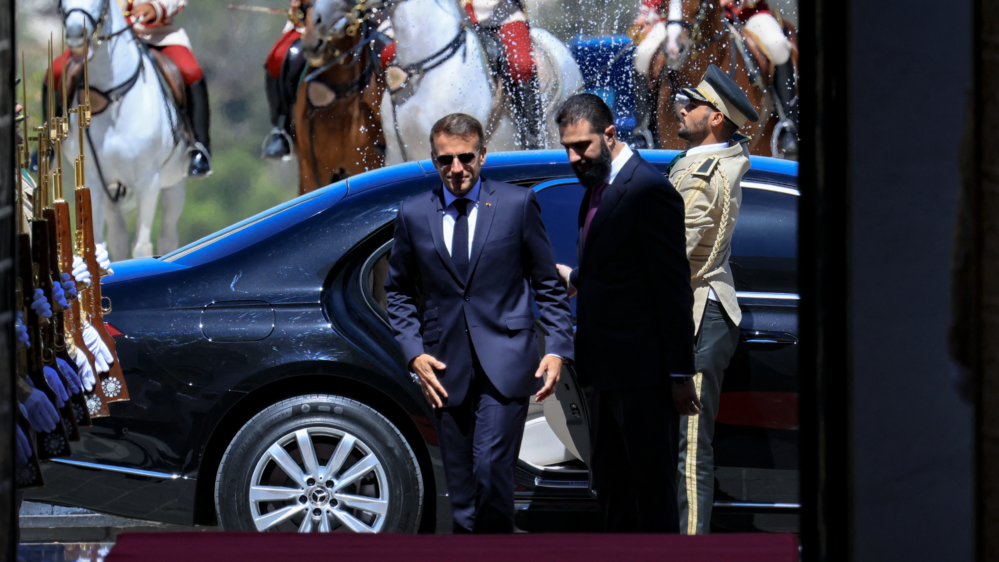 President Emmanuel Macron (L) and Syria's President Ahmed al-Sharaa arrive ahead of their meeting at the People's Palace in Damascus