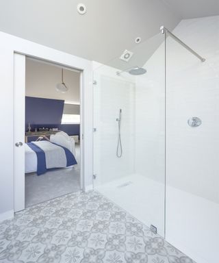 En suite bathroom with glass shower facing into bedroom