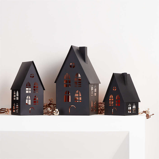 A white fireplace mantel with black Halloween-themed houses