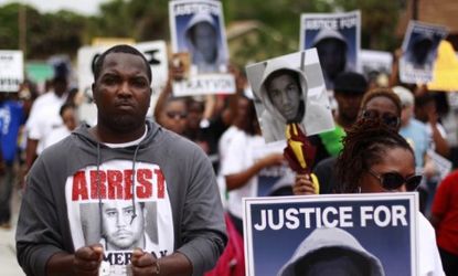 Demonstrators march in front of the Sanford Police Department in Florida: New analysis from voice experts pokes holes in George Zimmerman's claims that he shot Trayvon Martin in self-defense.