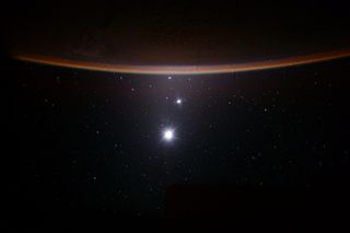 From bottom to top, the bright points in this image feature Earth's moon, Venus and Jupiter. The curved horizon at the top is Earth's crescent. Astronaut Scott Kelly captured this view from the International Space Station in 2015.