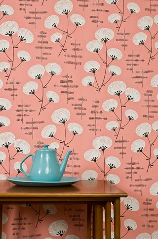 Retro pink wildflower wallpaper with mid-century tall table and blue ceramic teapot