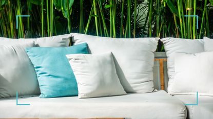 Garden couch with white cushions and one turquoise scatter cushion to support a cleaning guide on how to clean outdoor cushions