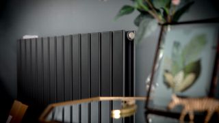 Black designer radiator at an angle with table in foreground
