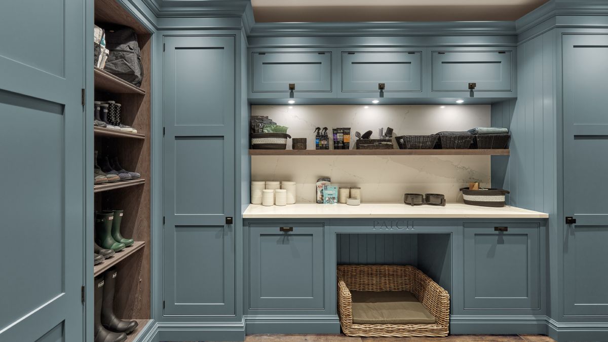 bootility room with blue cupboards, white worktop and dog bed underneath