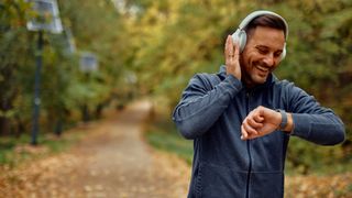 A man walking in the park checking his fitness tracker