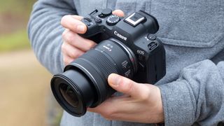 A man holding the Canon RF 16-28mm F2.8 IS STM attached to a Canon EOS R6 Mark II