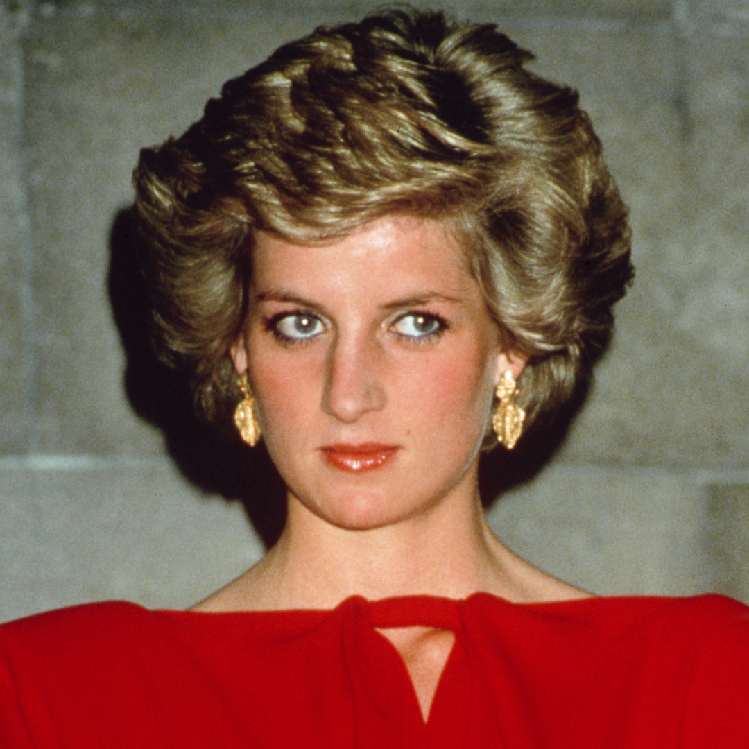 Princess Diana wearing a red off the shoulder dress and with blonde bouffant hair at a state reception in Melbourne, October 1988
