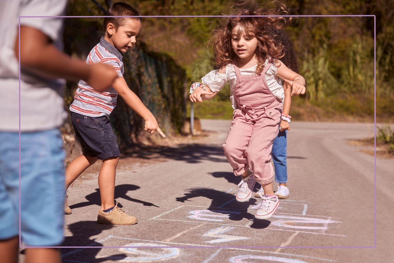 Group of kids having fun playing hopscotch on street 