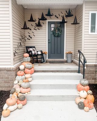 Fall porch idea with pumpkins stacked up, witches hat and rocking chair