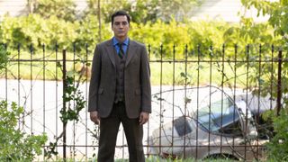 RAMÓN RODRIGUEZ as Will Trent standing in front of a wire fence and looking at the camera.