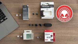 A selection of eartips on a table next to a laptop and pair of Sony XM6 earbuds