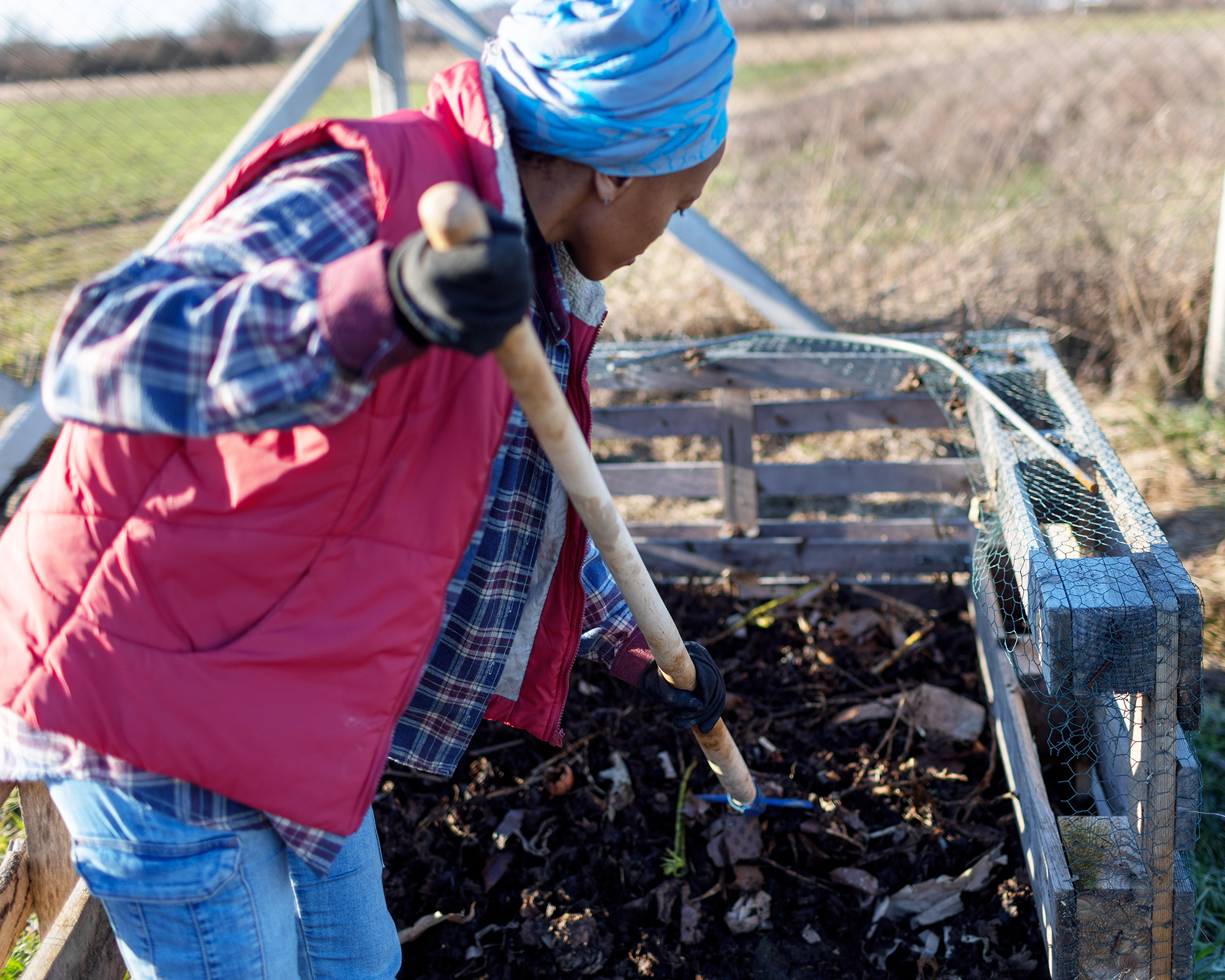 Woman turning compost heap