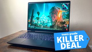 Alienware laptop on table with Cyberpunk 2077 on display with Tom's Guide Killer Deal badge