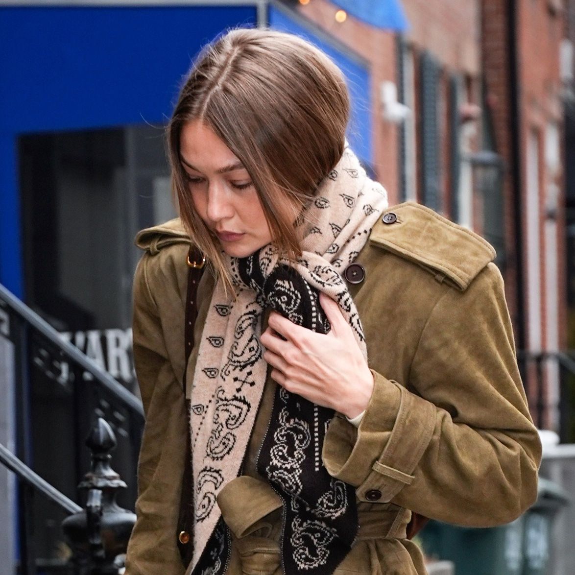 Gigi Hadid wearing a Guest in Residence Wild Rag scarf, suede Helsa coat, raw-hem jeans, and loafers in Manhattan