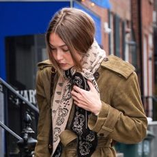 Gigi Hadid wearing a Guest in Residence Wild Rag scarf, suede Helsa coat, raw-hem jeans, and loafers in Manhattan