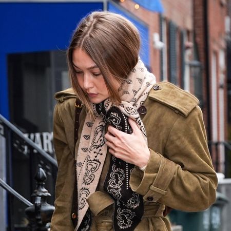 Gigi Hadid wearing a Guest in Residence Wild Rag scarf, suede Helsa coat, raw-hem jeans, and loafers in Manhattan