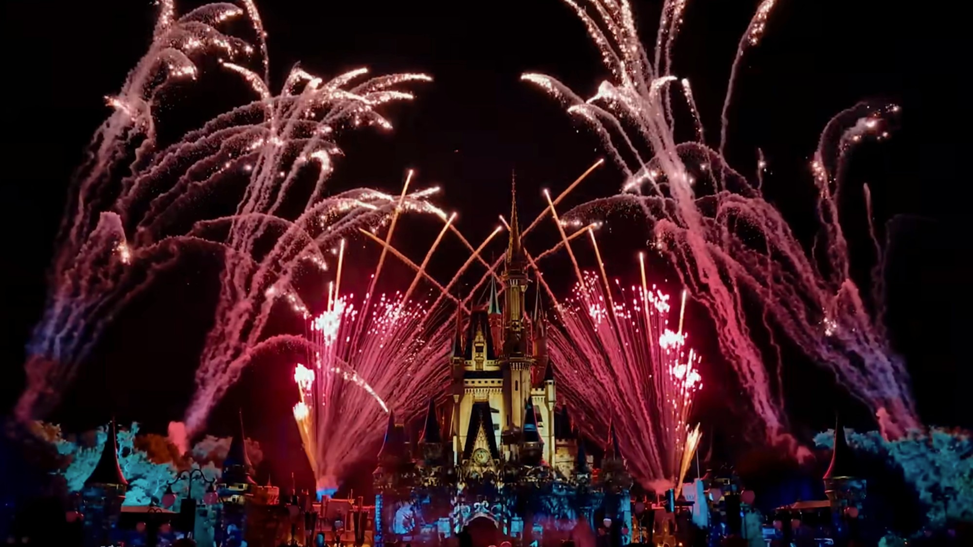Fireworks exploding over the castle at Disney World at night