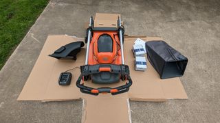 Unboxing the Husqvarna Lawn Xpert LE-322, showing the mower, batteries, grass catcher and other parts