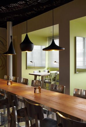 Restaurant of Mama Shelter, Istanbul with large lampshades and wooden tables and chairs