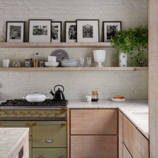 Frames on a kitchen shelves with a green stove below