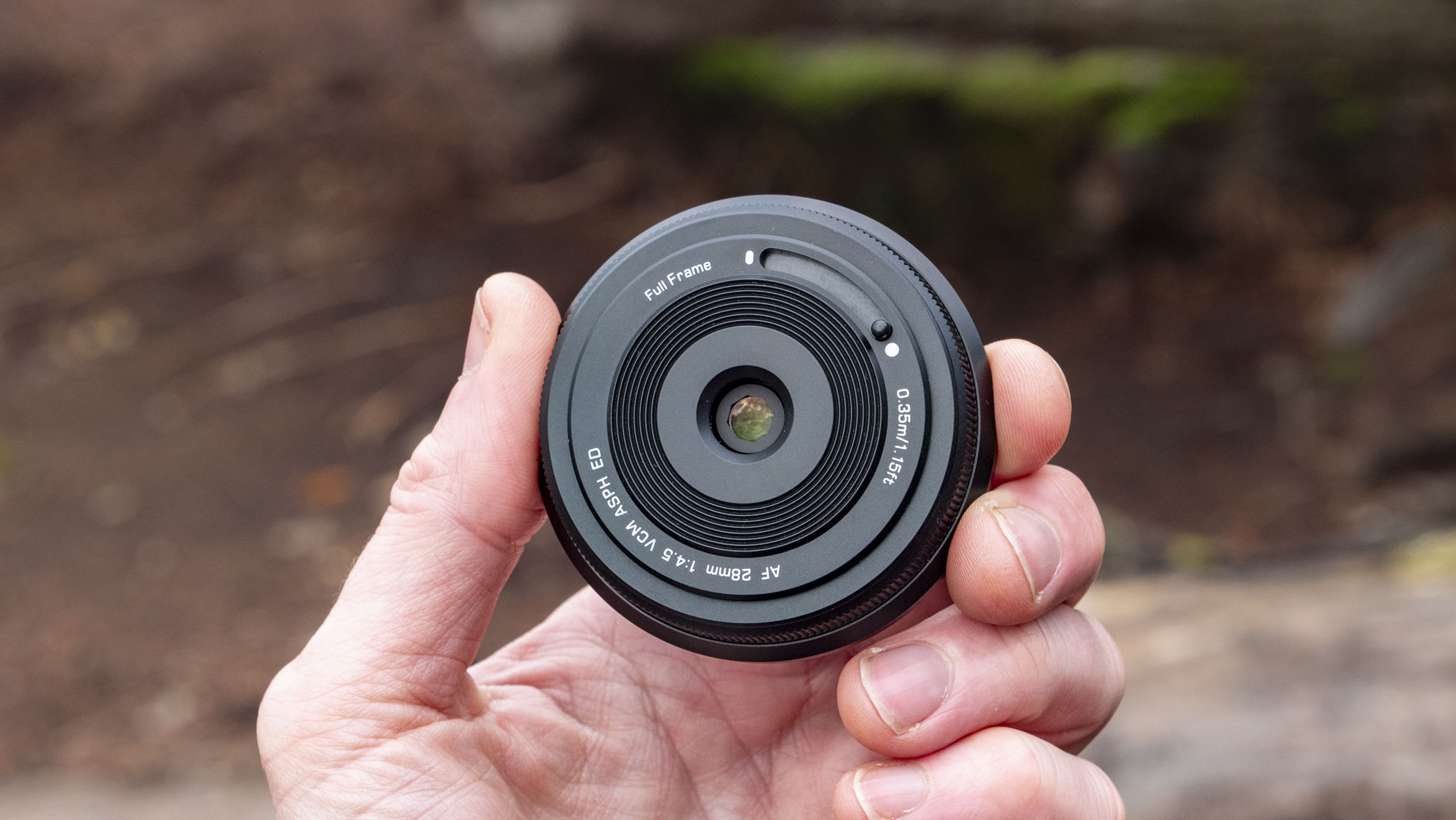 Viltrox AF 28mm f/4.5 body cap lens in photographer's hand