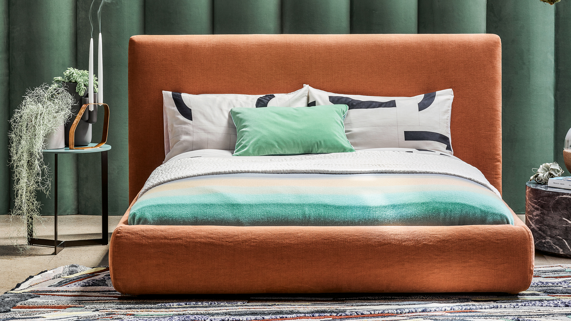 Green bedroom with a burnt orange linen bed