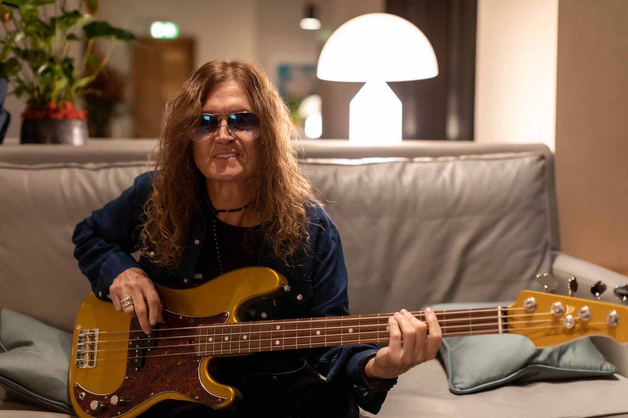 Glenn Hughes holds a bass guitar