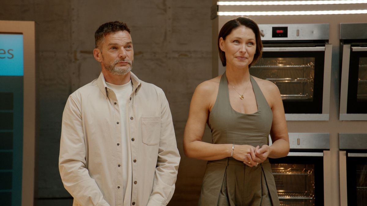 Fred Sirieix and Emma Willis stand in the studios of The World Cook&#039;s UK headquarters, with a wall of ovens behind them in the background