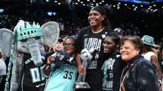 Jonquel Jones of the New York Liberty holds WNBA championship trophy