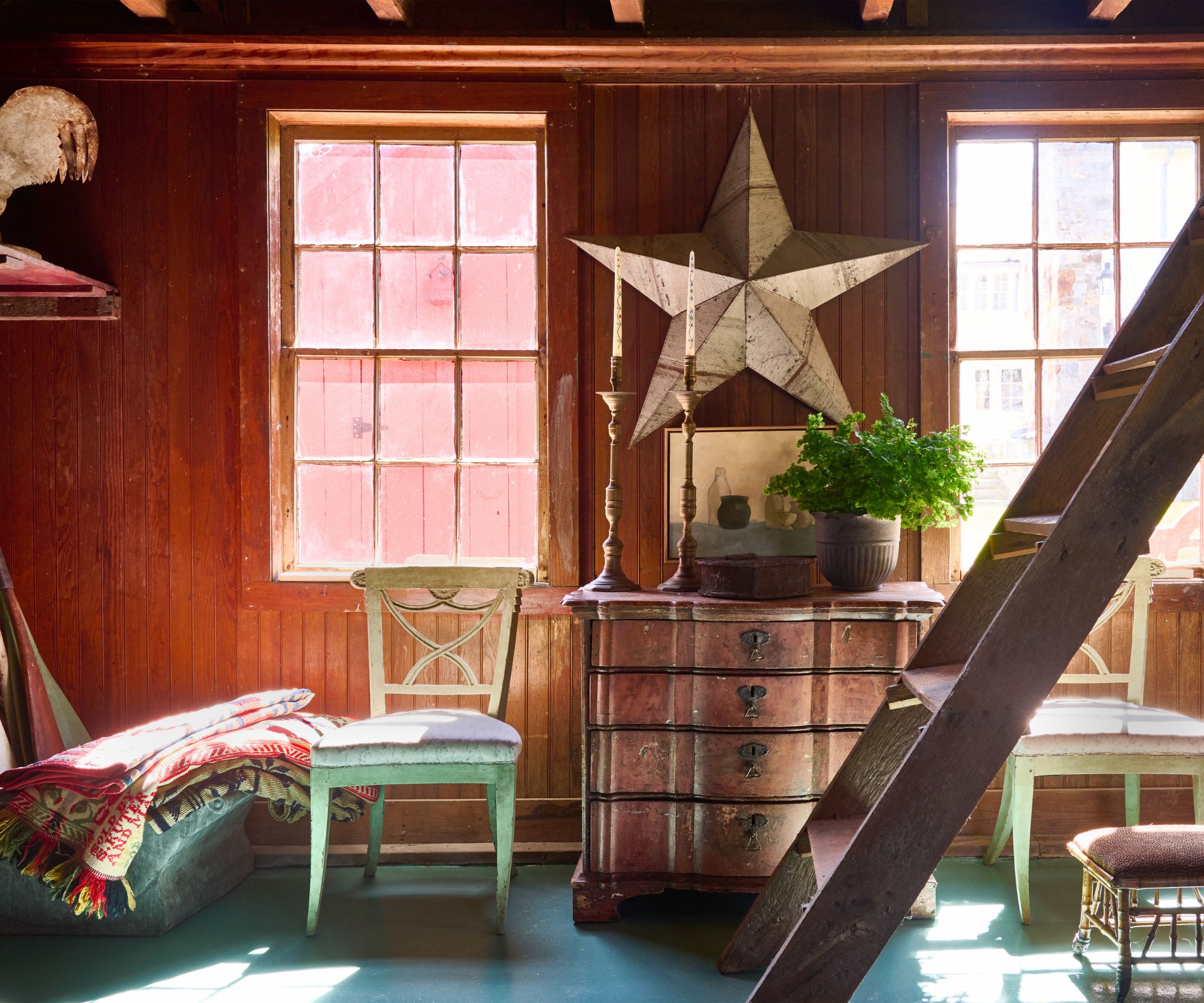 Red barn with antique dressed and green antique chairs