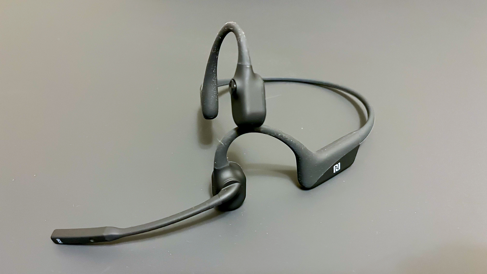 Shokz OpenComm UC on a gray surface