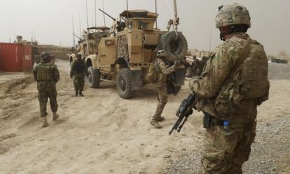 U.S. soldiers keep watch at the entrance of a U.S. base in Kandahar province Sunday, after an American sergeant allegedly went on a shooting spree, killing 16 civilians.