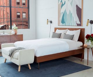A wood bed frame in a Mid-century bedroom