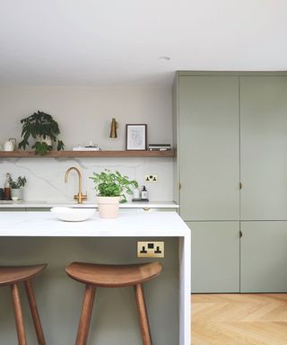 Sage green kitchen with white countertops