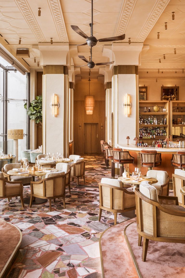 A naturally lit restaurant shows a terracotta-shaded decor inspired by mid-century modern style.