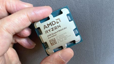A photo of an AMD Ryzen 9 9950X3D2 Dual Edition processor held between a person's finger and thumb