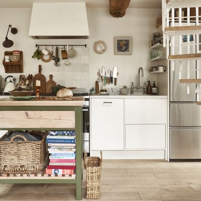 galley kitchen with small island with green metal frame and spiral staircase 