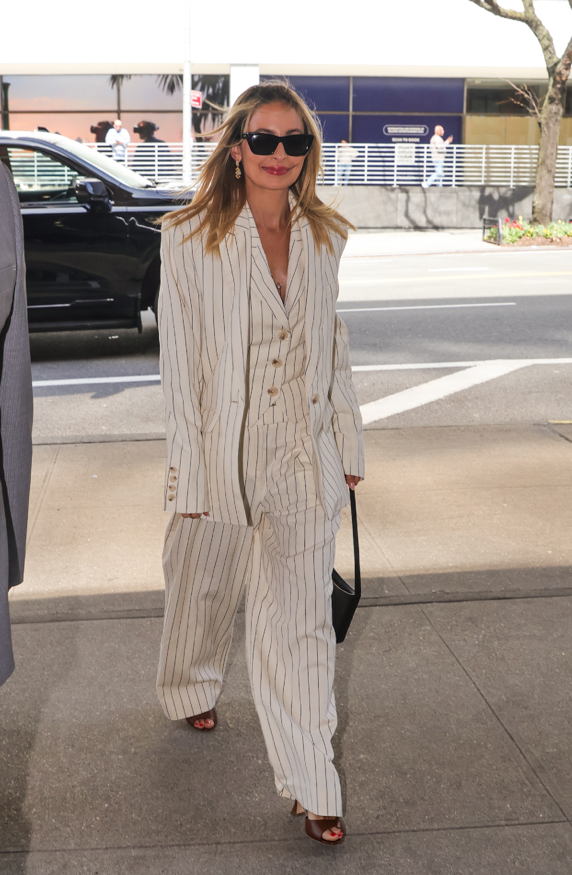 Nicole Richie wearing a white pinstripe three-piece suit with sunglasses.