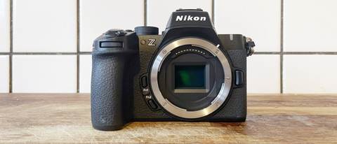 Nikon Z50 II camera on a wooden surface in front of white tiled wall