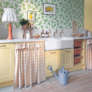 Bathroom with yellow shaker cabinets and cafe curtain.