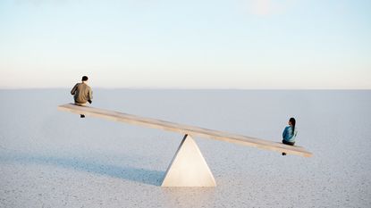 man and woman sat on each end of a balance bar